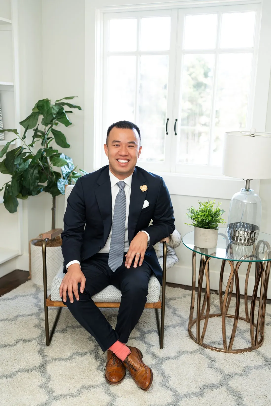 Ken Er seated in an armchair in a bright, staged living room